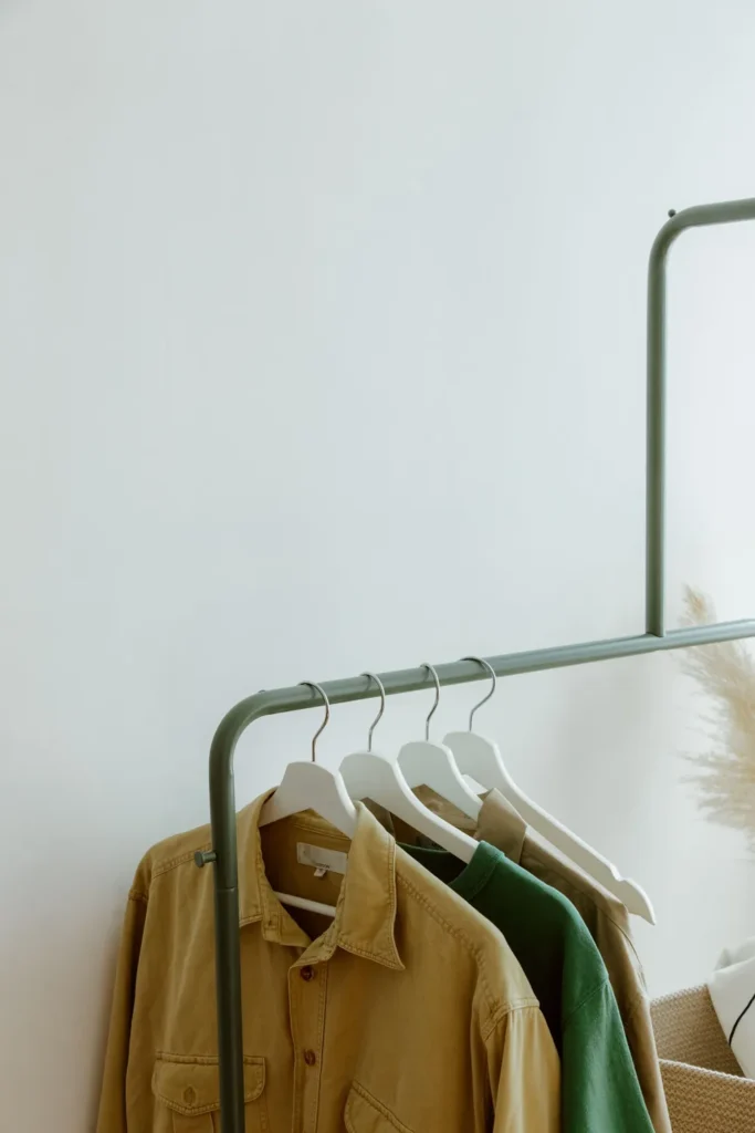 Casual shirts and a green top hanging on a clothing rack