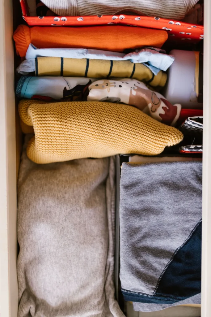 Folded clothes arranged neatly inside a drawer.