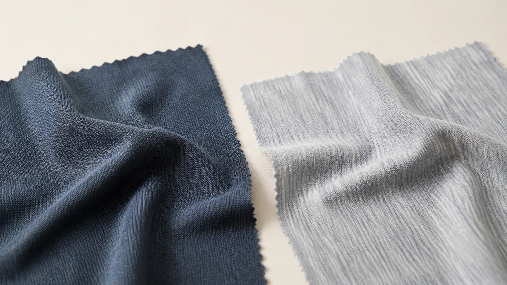 Navy and light gray knitted fabric samples arranged side by side for Merino wool fabric selection.