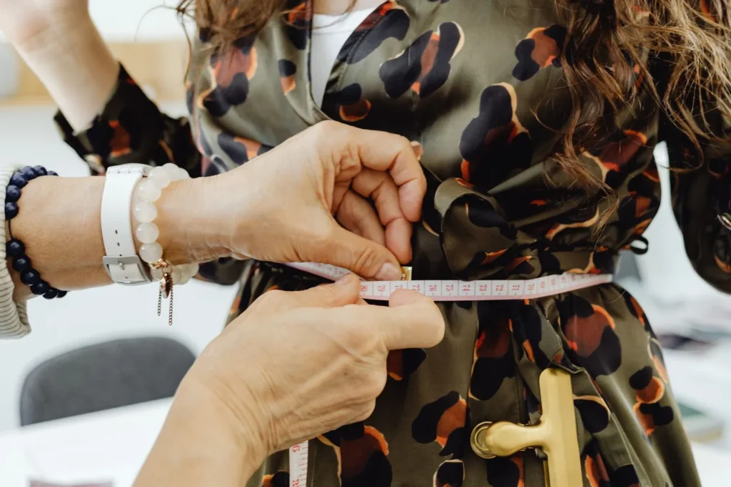 A measuring tape held around a garment during a fitting